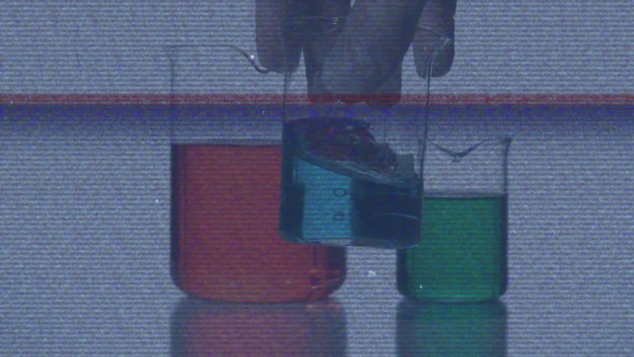 Animation of glitch over hand in safety gloves holding chemical reagents