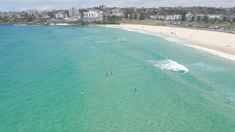 surfers surfing at bondi beach by blue sea in summer in bondi, nsw, australia