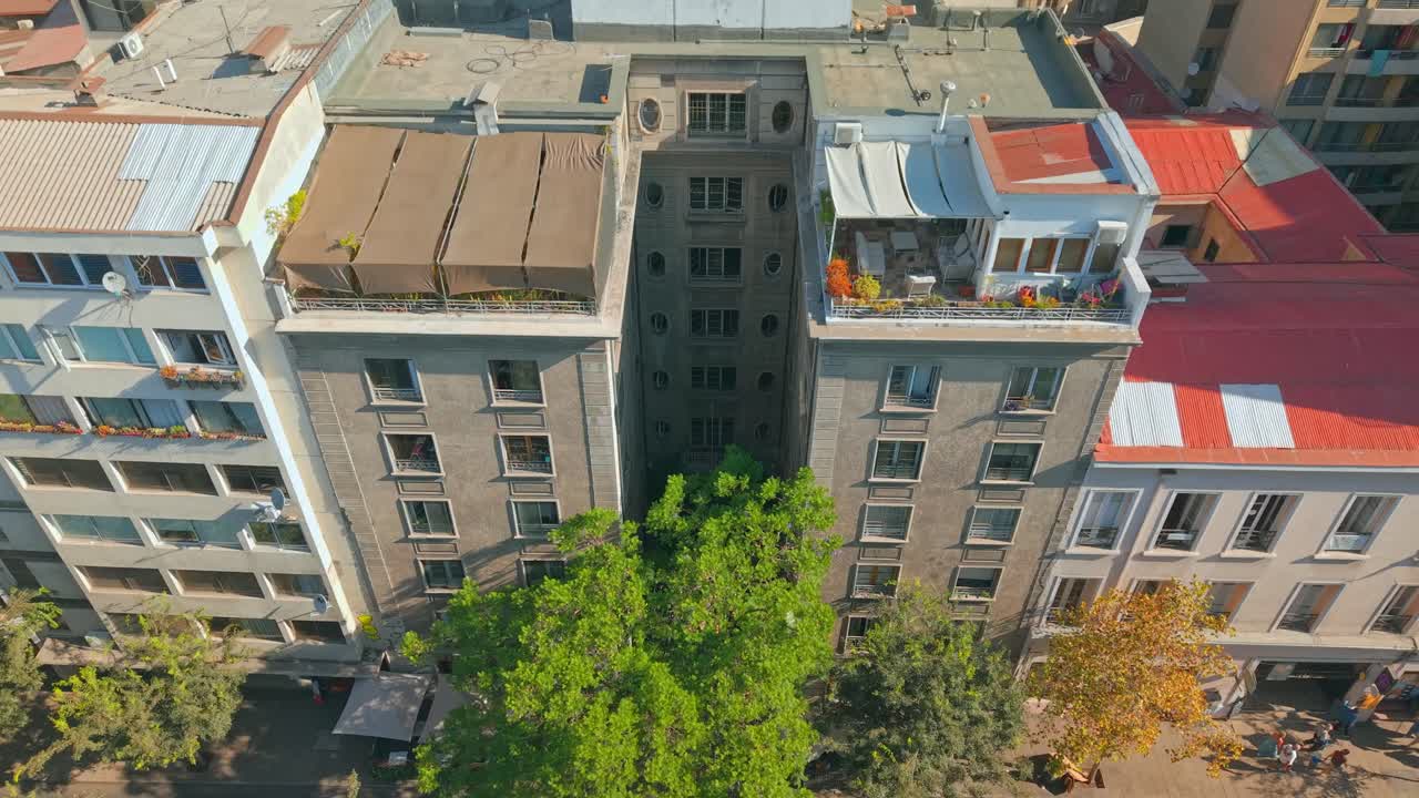 Drone aéreo sobrevoando telhados em um bairro central de Santiago, Chile.