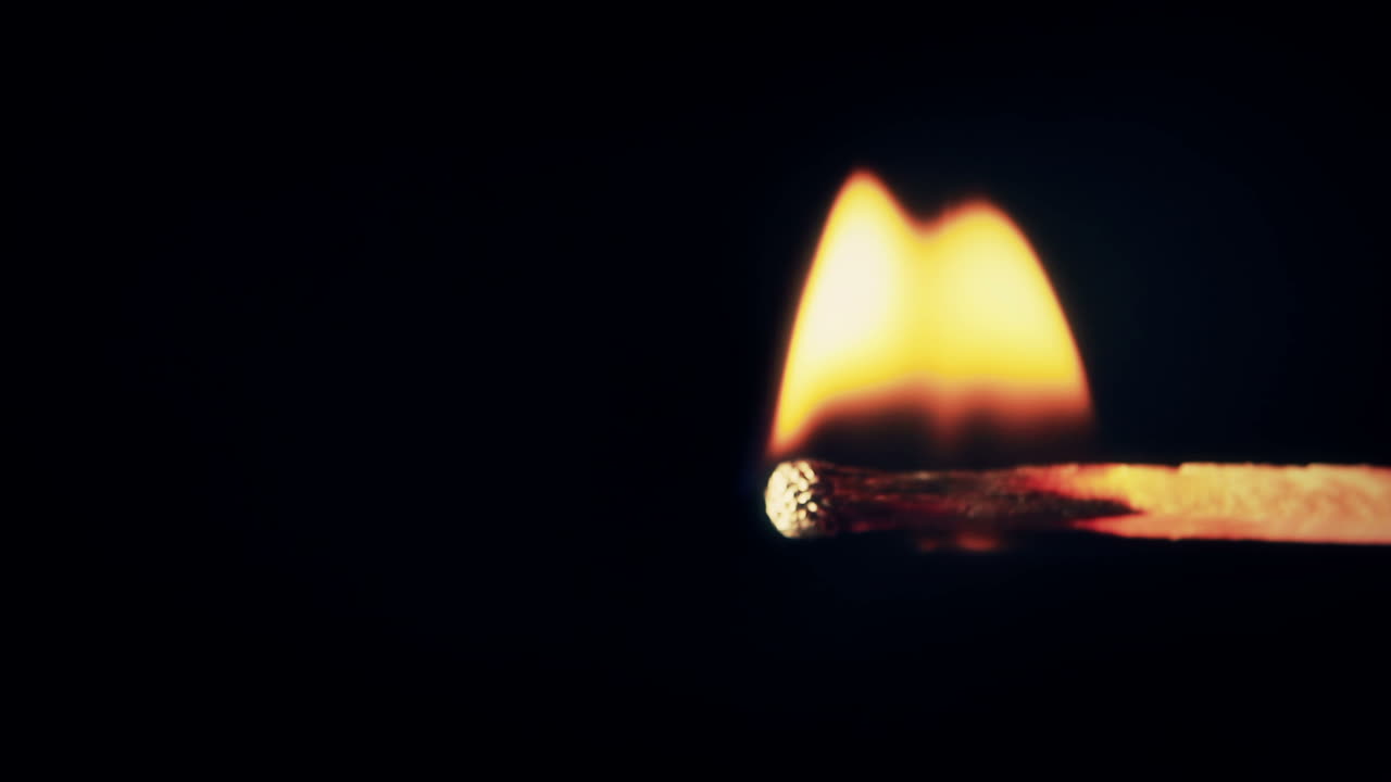 Primo piano di un fiammifero che si accende e brucia con una fiamma brillante