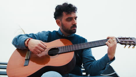 man immersed in the music of his guitar outdoors