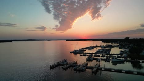 Aerial-ascent-of-sunset-and-Hessel-Marina,-Michigan