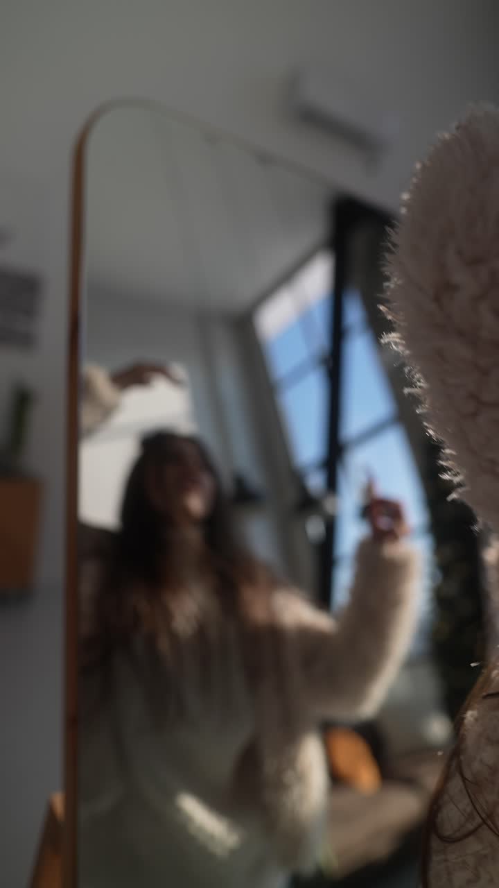 Donna che si acconcia i capelli davanti a uno specchio
