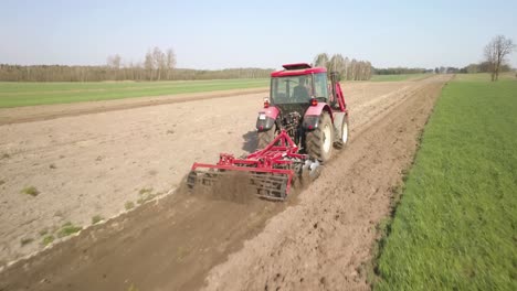 Drohnen-Verfolgen-Nahaufnahme-Einer-Landwirtschaftlichen-Traktormaschine,-Die-Land-Für-Die-Aussaat-Pflügt-Und-Vorbereitet