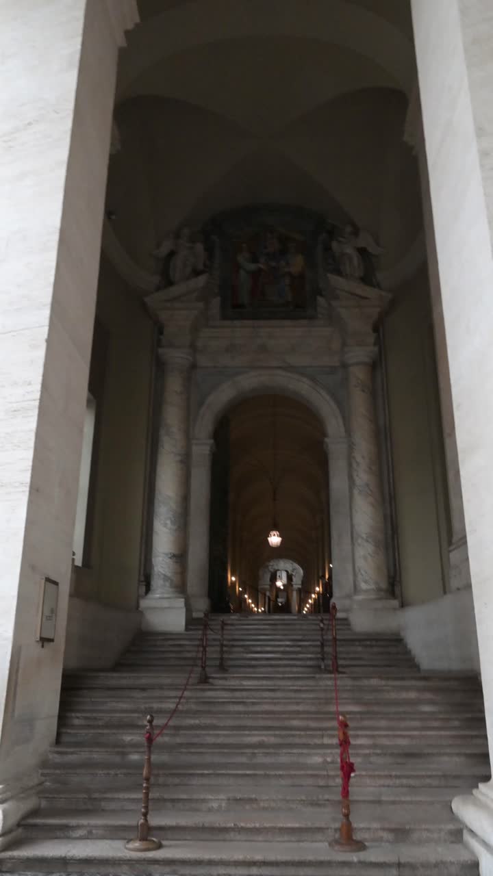 Intricati rilievi in bronzo e dettagli architettonici su un ingresso laterale a portale che conduce alla navata principale della storica Basilica Vaticana.