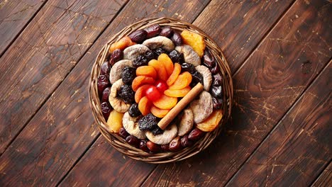 mix of dried fruits in a small wicker basket on wooden table