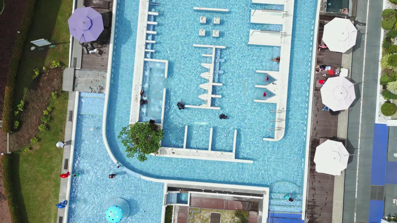 A stunning 360 dolly-out drone shot reveals a luxurious pool beside a grand hotel, seamlessly blending relaxation and elegance.