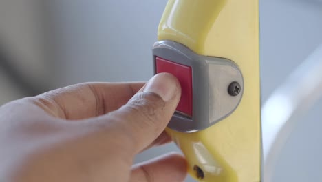 person pressing emergency button on bus