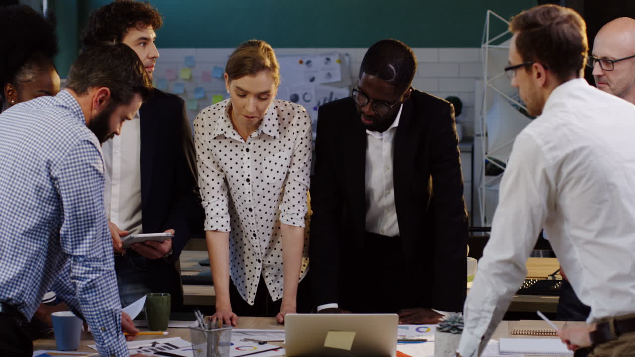 Multiethnic business team analyzing documents, charts, financial reports and graphics in the office