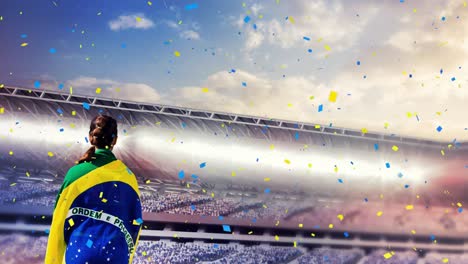 Animation-of-confetti-floating-over-back-of-woman-with-brazilian-flag-at-stadium