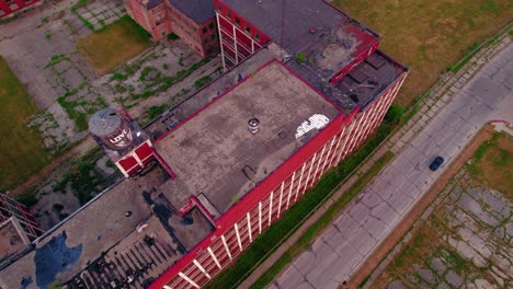 Antena-Dinámica-Mientras-Se-Conduce-Un-Camión-Junto-A-Un-Edificio-Rojo-Abandonado-Con-Una-Simetría-Y-Un-Patrón-Fuertes