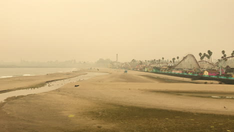 Cold-misty-yellow-day-at-beach-at-boardwalk-with-games-and-entertainment-attractions