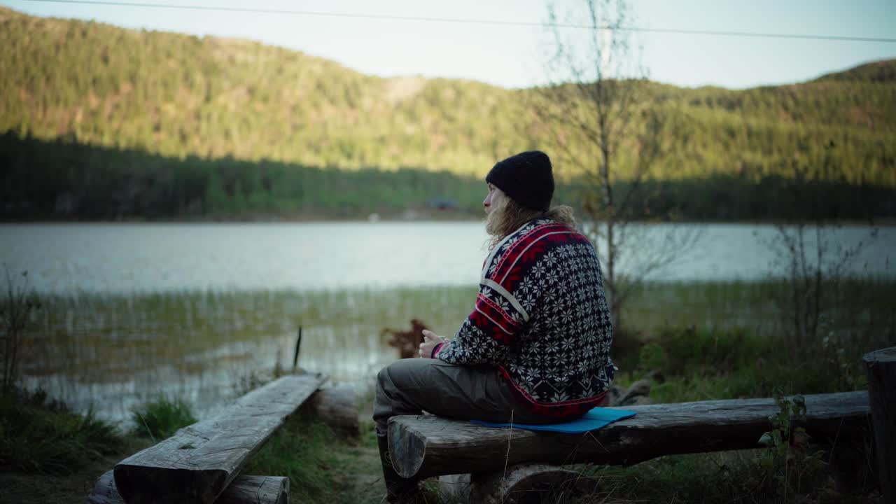 hildremsvatnet, condado de trondelag, noruega - un hombre disfrutando de una bebida caliente junto al lago - toma estática