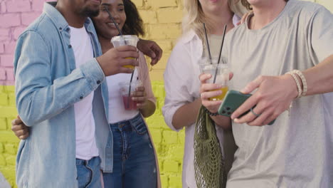 Grupo-De-Jóvenes-Amigos-Tomándose-Selfies-Juntos-Y-Divirtiéndose-Al-Aire-Libre,-Mientras-Sostenían-Y-Bebían-Bebidas-Frescas-En-Vasos-De-Plástico