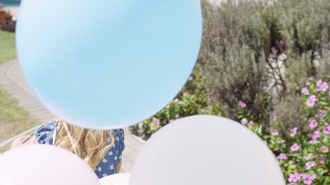 천천히 움직이는 풍선과 함께 달리는 작은 금발 소녀