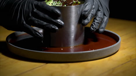 movimiento lento de un camarero con guantes de látex negro sirviendo un timbale de mariscos en un restaurante tradicional mexicano
