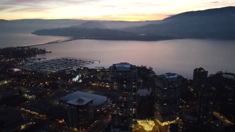 drone shot of kelowna city appartment buildings on okanogan lake with sunset