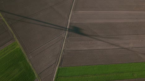 Schatten-Einer-Windturbine-über-Ausgedehntem-Ackerland-Von-Oben-Gesehen