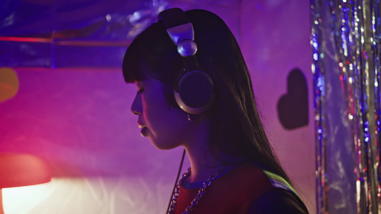 Girl DJ mixing music at trendy disco bar concentrated in performance closeup