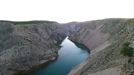 Tourist-standing-on-the-edge-of-the-Zrmanja-canyon-which-is-very-risky-to-climb-in-Jasenice,-Zadar-County,-Croatia