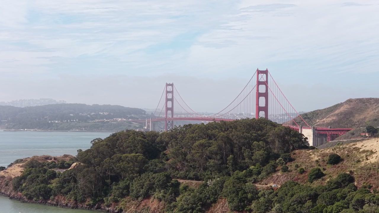 Et luftperspektiv fra Sausalito viser Golden Gate Bridge mod San Francisco-bugten, der fremhæver dens karakteristiske arkitektur, omkringliggende bakker, kystlinje og forbindelse til byen.