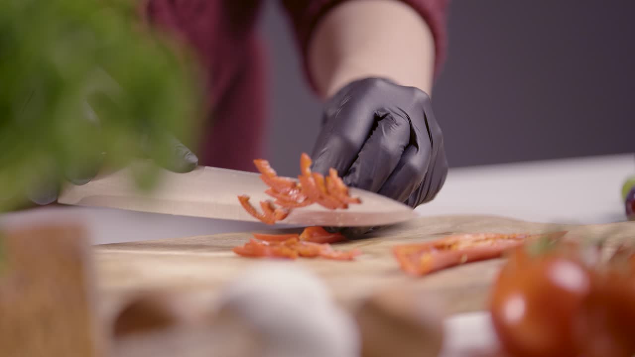 chef slicing fresh red chili peppers on a wooden board. The sharp knife glides effortlessly, revealing vibrant textures and scattered seeds, creating a visually captivating culinary scene