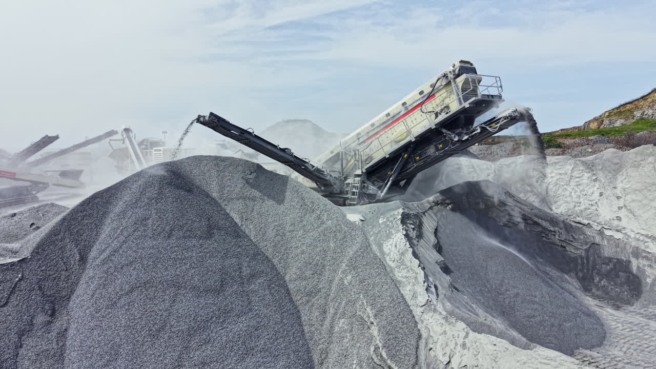 Granite quarry operation with heavy machinery creating piles of stone at the worksite in daylight