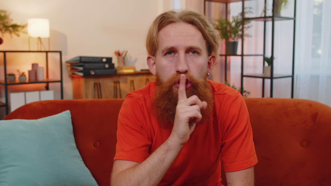 el joven presiona el dedo a los labios hace silencio signo de silencio no dice chismes secreto, tranquilo en casa