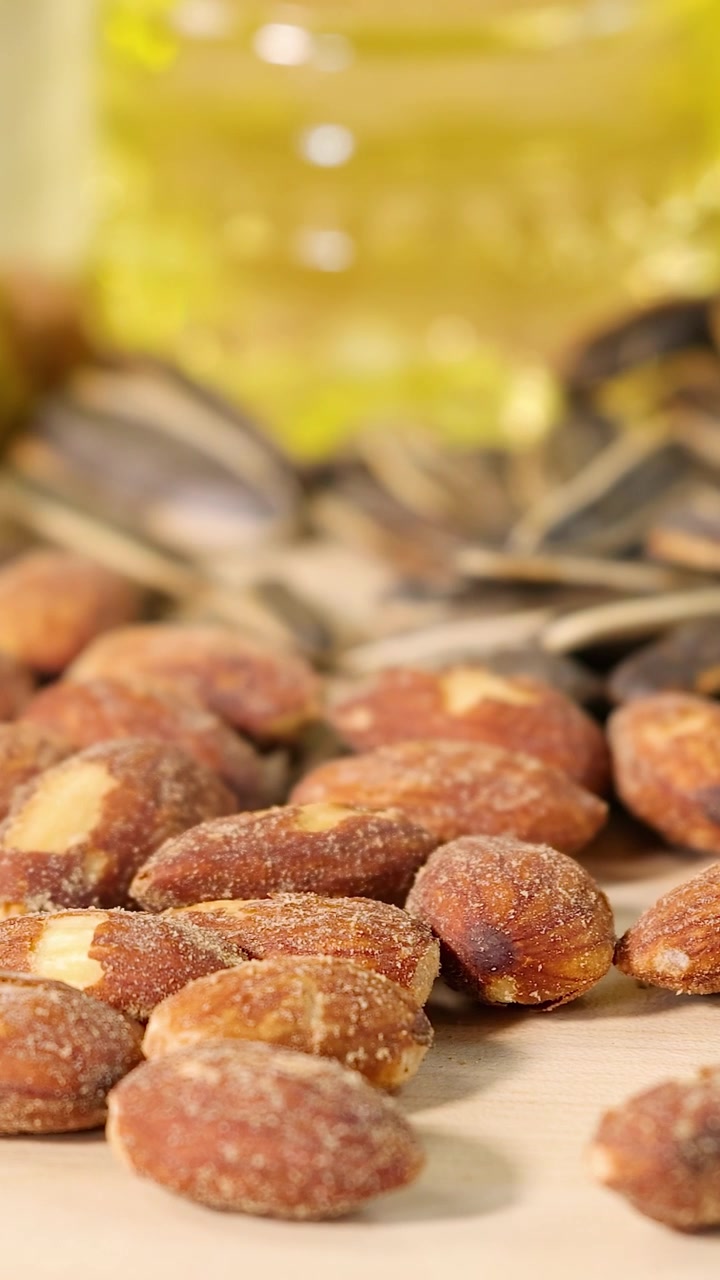 Close-up visuals of various healthy fats including avocados, bacon, butter, seeds, and nuts in bright lighting