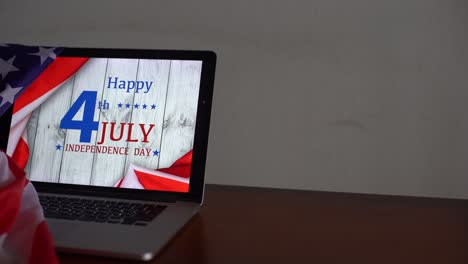 American-flags-with-inscription-Happy-Independence-Day-on-laptop