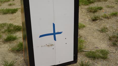 Blue Cross Mark On A Target Object Standing In An Outdoor Firing Range