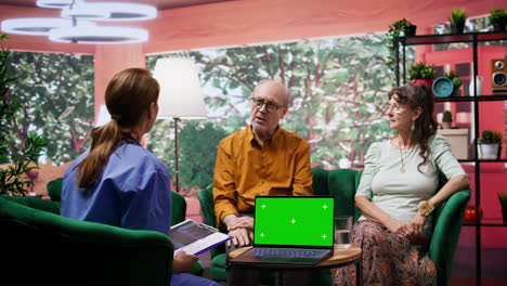 nurse giving professional advice to her senior patients next to green screen