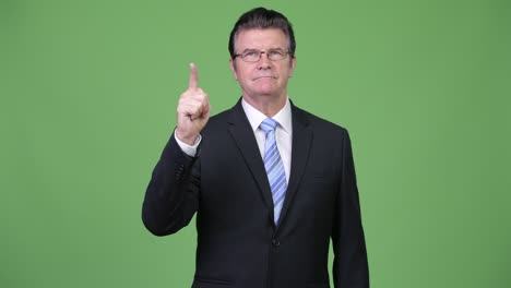 Senior handsome businessman pointing up