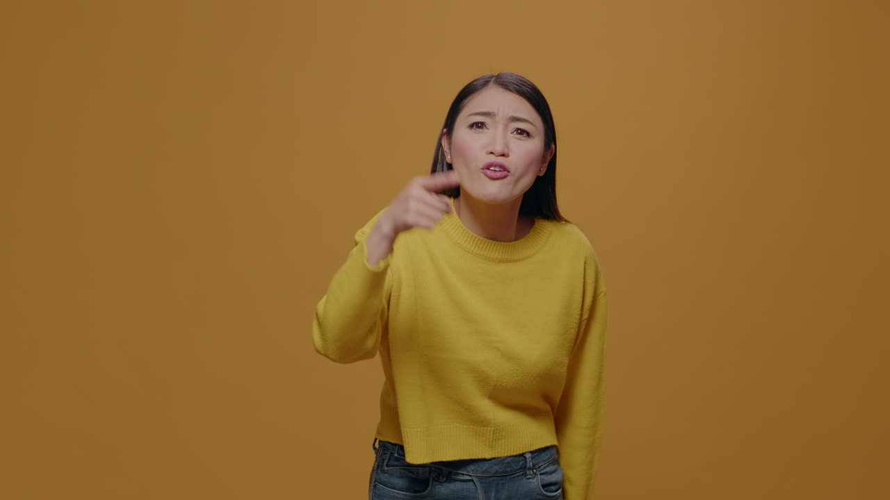 Angry woman showing index finger at camera and having argument