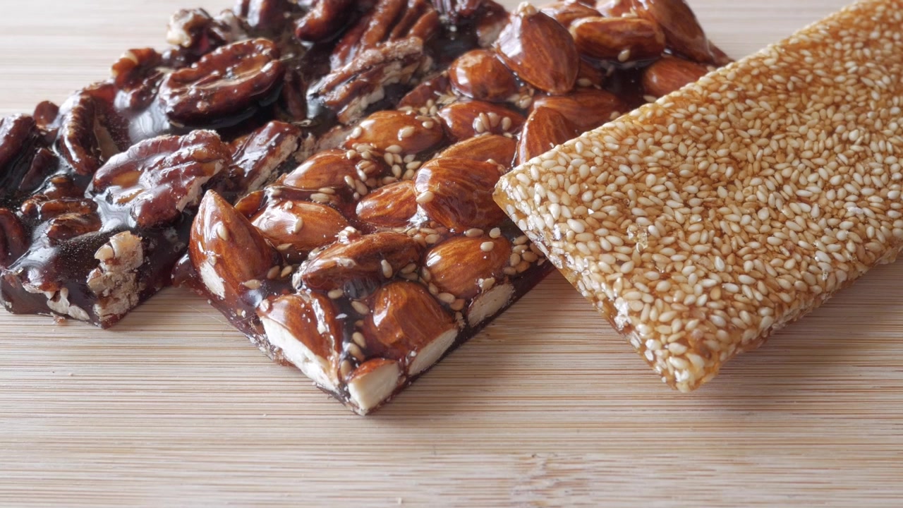Utzooming av tradisjonelle spanske Guirlaches. Nougat- og sesambarer med honning.