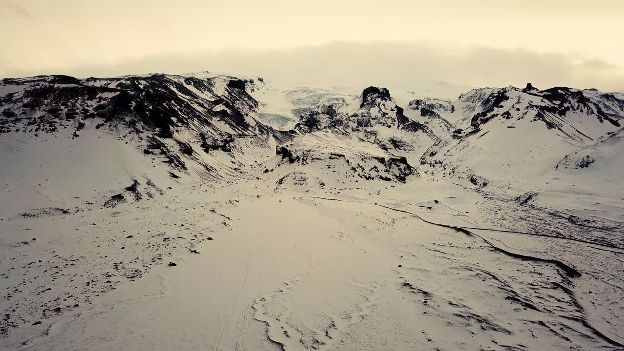 Spettacolare paesaggio montano ripreso con drone in condizioni invernali, con luce del tramonto.