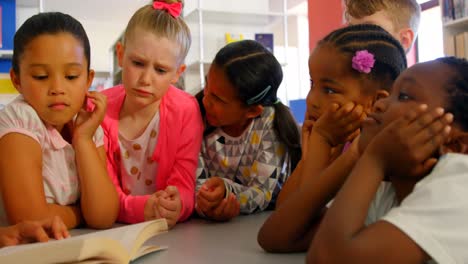 maestra asiática que enseña a los escolares en la biblioteca de la escuela 4k