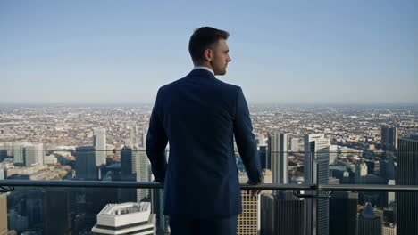 businessman looking at city skyline from rooftop