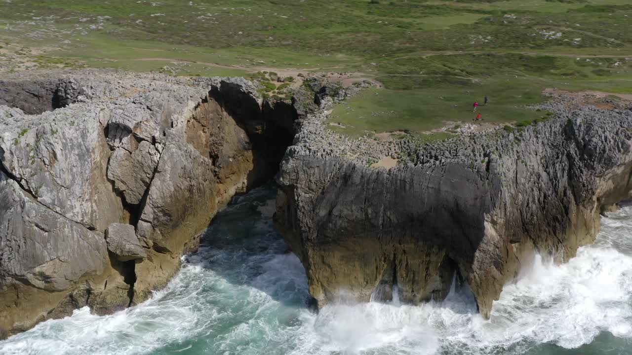 Explorers roam on lush green grassy flats above bufones de pria asturias spain sea cliffs