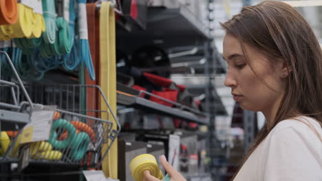 mujer comprando bandas de resistencia en una tienda de equipos deportivos