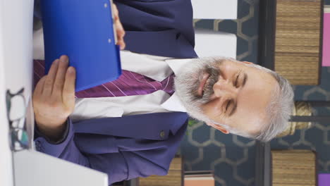 vertical video of positive old businessman closes paperwork files.