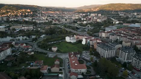 sunset drone of ourense, spain, capturing the city’s layout and scenic river surrounded by historic architecture