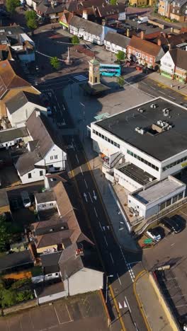 portrait reversing drone over hoddesdon high street, with bus, shops, car park