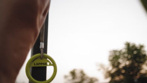 healthy lifestyle athletic man performing strength exercise for upper-body on pull up bar at beach gym