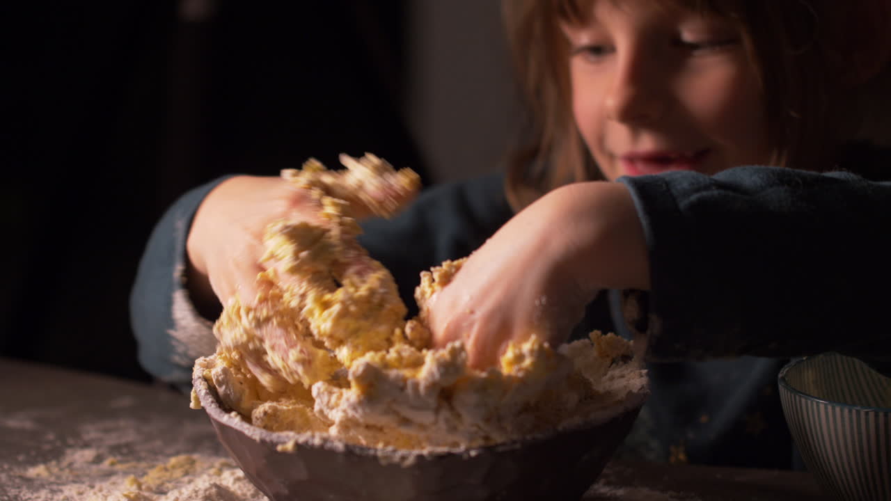 Adorable little girl with messy hands mixing butter, flour dough mix in bowl
