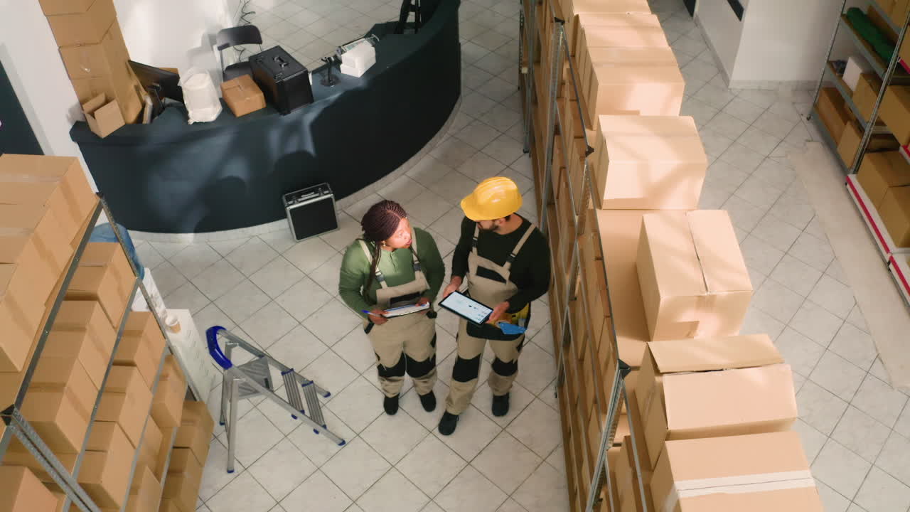 Warehouse workers checking inventory with clipboard and digital tablet