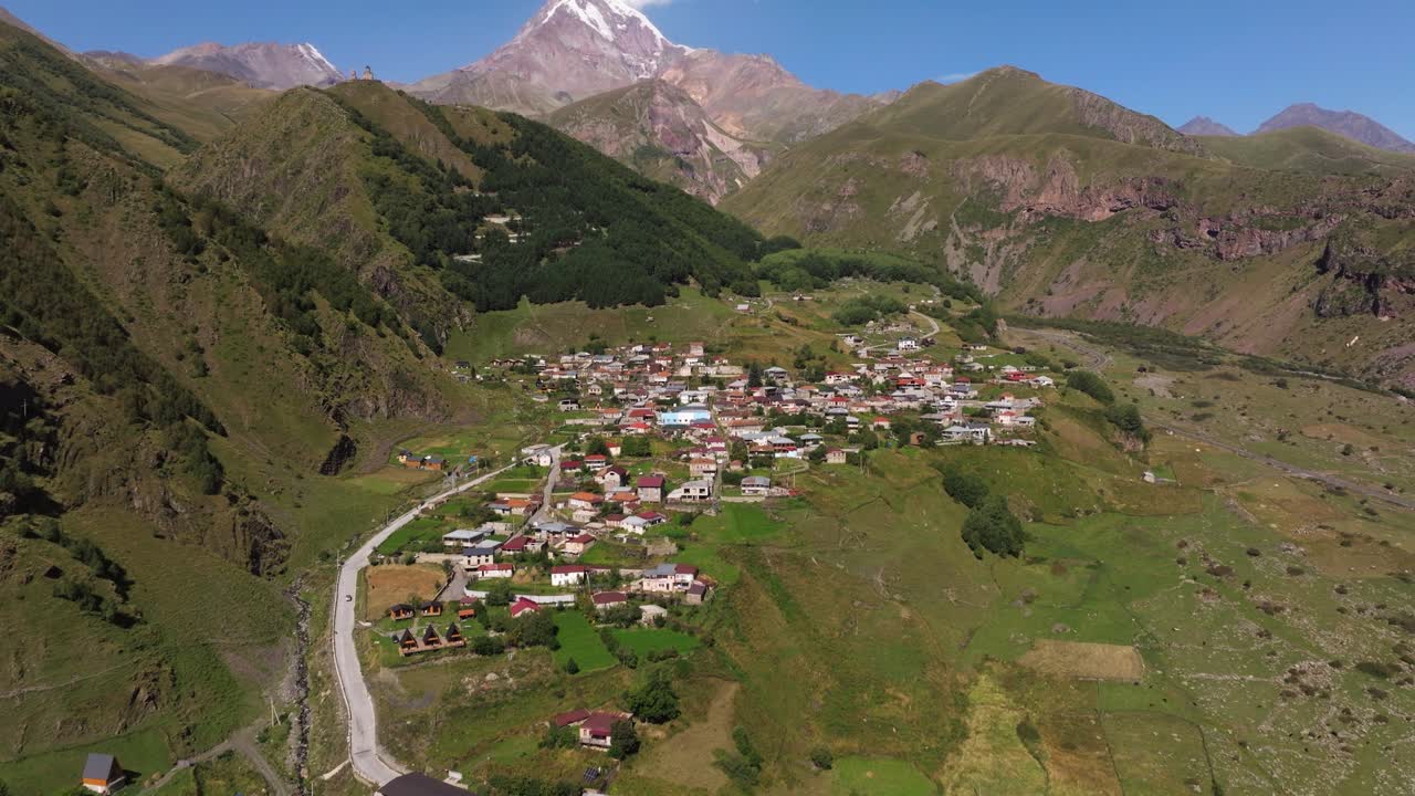 Panoramica aerea verso l'alto rivela Gergeti, Georgia.