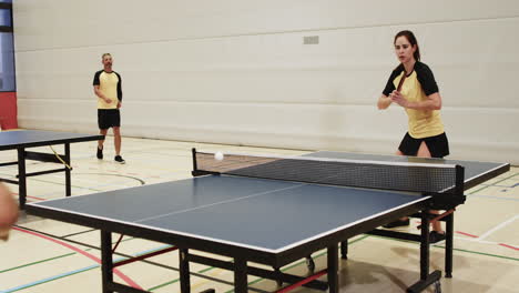 playing table tennis, two women competing in indoor sports facility
