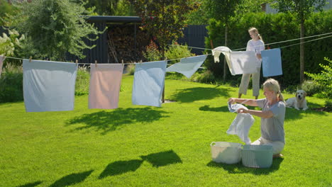 family drying laundry in backyard