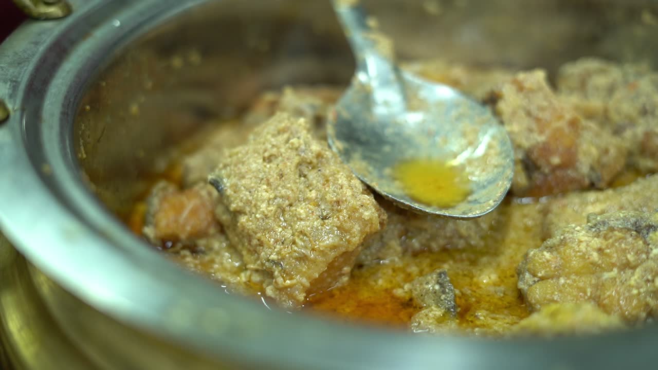 cocina bengalí - doi katla en un plato servido con arroz blanco con chile rojo seco y hojas de cilantro sobre fondo de madera